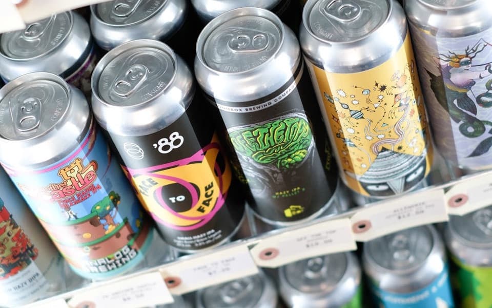 Cans of craft beer on the shelf at Sip Liquor Market