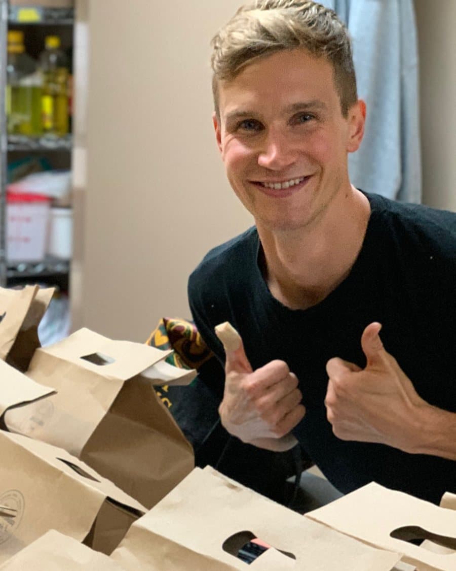 Conner Kadziolka giving two thumbs up beside a table of packed orders