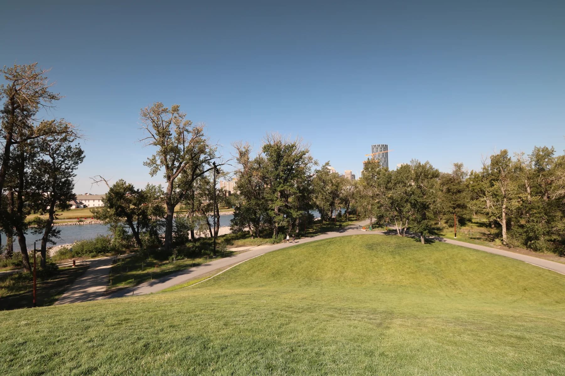 The lawn, riverside paths and Calgary skyline from the hill at St. Patrick’s Island